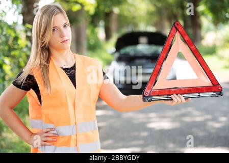 Une jeune femme se casse avec sa voiture Banque D'Images