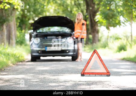 Une jeune femme se casse avec sa voiture Banque D'Images