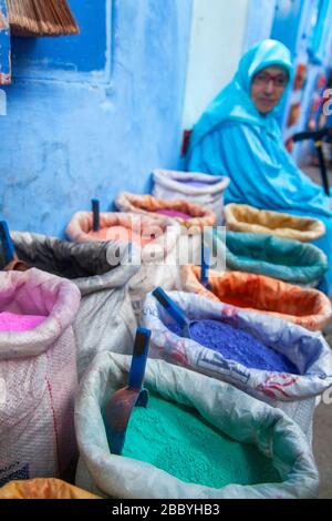 Chefchaouen, Maroc : femme vendant de la poudre de couleur dans la Médina Banque D'Images