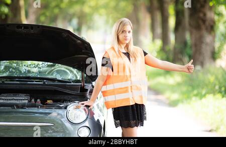 Une jeune femme se casse avec sa voiture Banque D'Images