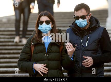 Rome, Italie, 25 février 2020. Les touristes portent des masques pour se protéger du Covid-19 sur les marches espagnoles. Banque D'Images