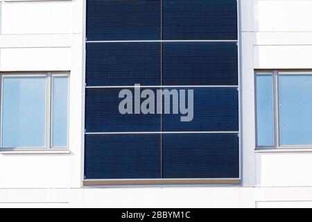 Bâtiment blanc avec panneaux solaires installés sur les murs extérieurs. Banque D'Images