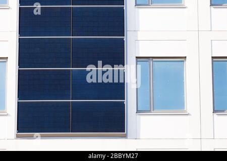 Bâtiment blanc avec panneaux solaires installés sur les murs extérieurs. Banque D'Images