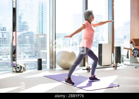 Femme chinoise senior s'exerçant à la salle de gym Banque D'Images