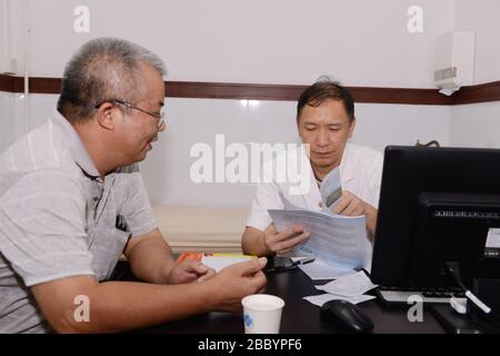 Zhongshan, Guangdong, Chine-14 juin 2018: Le médecin a demandé au sujet de la santé du patient afin de prendre le contrôle corporel pour le patient dans la ville de Guzhen Banque D'Images