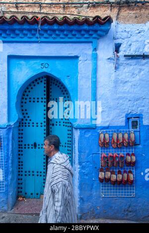 Chefchaouen, Maroc: Homme dans une jillaba traditionnelle marchant dans la médina. Banque D'Images
