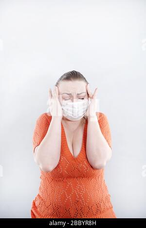 Près d'une femme d'âge moyen portant un masque de protection, en regardant de côté l'espace de copie, isolée sur fond gris. Grippe, allergie, protection contre le virus Banque D'Images