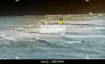 Une image panoramique d'un bateau à kite solitaire qui écume à vitesse sur la mer à Crantock, à Newquay, en Cornouailles. Banque D'Images