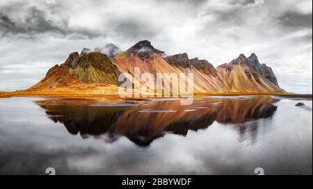 Magnifique paysage des célèbres montagnes Stokksnes sur le cap de Vestrahorn. Réflexion dans l'eau claire sur l'arrière-plan épique du ciel, l'Islande Banque D'Images