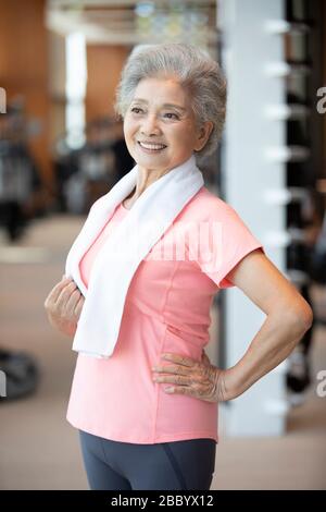 Femme chinoise senior prenant une pause après avoir fait de l'exercice à la salle de gym Banque D'Images
