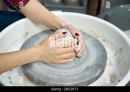 Femme faisant de la poterie céramique, quatre mains près, se concentrer sur des potiers, des palmiers avec poterie Banque D'Images