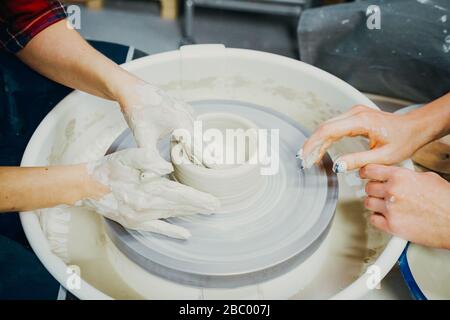 Femme faisant de la poterie céramique, quatre mains près, se concentrer sur des potiers, des palmiers avec poterie Banque D'Images