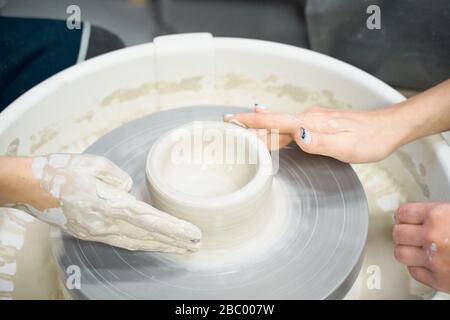 Femme faisant de la poterie céramique, quatre mains près, se concentrer sur des potiers, des palmiers avec poterie Banque D'Images