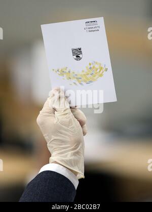 Magdeburg, Allemagne. 02 avril 2020. Un membre du Landtag portant des gants en caoutchouc tient une carte de vote pendant la session Landtag. Jeudi, le parlement de l'État a l'intention d'adopter le budget supplémentaire de 500 millions d'euros pour faire face à la crise de Corona en deuxième lecture. Crédit: Ronny Hartmann/dpa/Alay Live News Banque D'Images