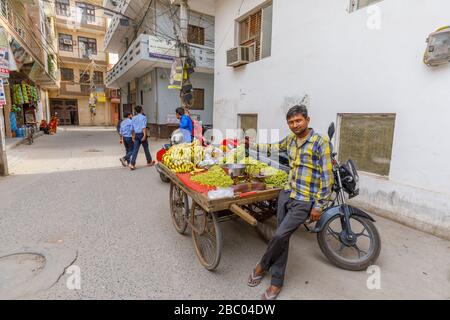 Homme local vendant des fruits d'un barrow au bord de la route: Scène de rue dans le quartier de Mahipalpur, une banlieue près de l'aéroport de Delhi à New Delhi, capitale de l'Inde Banque D'Images