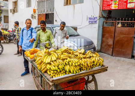 Homme local vendant des fruits d'un barrow au bord de la route: Scène de rue dans le quartier de Mahipalpur, une banlieue près de l'aéroport de Delhi à New Delhi, capitale de l'Inde Banque D'Images