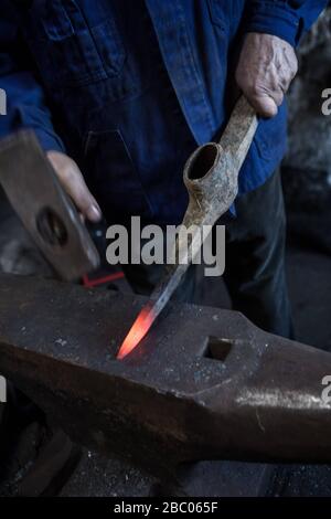 Un piquex est battu à l'enclume avec un marteau dans le smithy du Hachlschmith à Josefsthal à Schliersee. Le marteau smithy existe depuis plus de 300 ans et fournit non seulement des travailleurs forestiers régionaux et des agriculteurs forestiers, mais aussi une grande entreprise de construction avec des outils. [traduction automatique] Banque D'Images