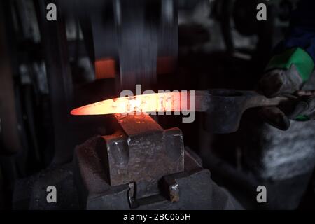 Un piquex est battu à l'enclume avec un marteau dans le smithy du Hachlschmith à Josefsthal à Schliersee. Le marteau smithy existe depuis plus de 300 ans et fournit non seulement des travailleurs forestiers régionaux et des agriculteurs forestiers, mais aussi une grande entreprise de construction avec des outils. [traduction automatique] Banque D'Images