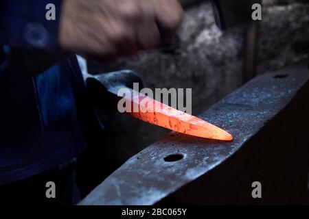 Un piquex est battu à l'enclume avec un marteau dans le smithy du Hachlschmith à Josefsthal à Schliersee. Le marteau smithy existe depuis plus de 300 ans et fournit non seulement des travailleurs forestiers régionaux et des agriculteurs forestiers, mais aussi une grande entreprise de construction avec des outils. [traduction automatique] Banque D'Images