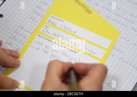 Les jeunes participants du club de lecture de la bibliothèque publique de Neuhausen présentent un livre dans un délai et écrivent ensuite une recommandation de livre. [traduction automatique] Banque D'Images