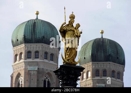 La statue de la Vierge Marie sur la Marienplatz de Munich avec les tours de la Frauenkirche en arrière-plan. [traduction automatique] Banque D'Images