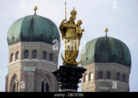 La statue de la Vierge Marie sur la Marienplatz de Munich avec les tours de la Frauenkirche en arrière-plan. [traduction automatique] Banque D'Images