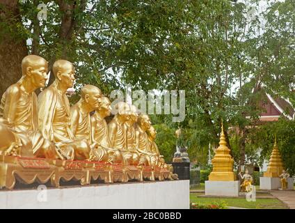 Une rangée de statues de moine doré dans le jardin du temple Wat Phra que Chae Haeng. Banque D'Images