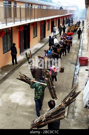 (200402) -- NANNING, 2 avril 2020 (Xinhua) -- les ménages pauvres du groupe ethnique Dong portent leurs biens familiaux sur le chemin de leurs nouvelles maisons du village de Rongdi dans le canton de Sirong dans le comté autonome de Rongshui Miao, région autonome du Guangxi Zhuang en Chine méridionale, 26 janvier 2018. La région autonome de Guangxi Zhuang, une région clé des efforts de lutte contre la pauvreté en Chine, a entraîné l'identification et la mise en place de dossiers pour environ 710 000 personnes déplacées de zones inhospitalières au cours de la 13ème période du Plan quinquennal (2016-2020) comme une lutte clé contre la pauvreté. Le programme de réinstallation a été terminé b Banque D'Images