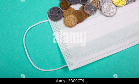 hausse des prix des masques médicaux, du masque protecteur et d’une poignée de pièces sur fond bleu hausse des prix de la médecine due à la pandémie de coronaviru Banque D'Images