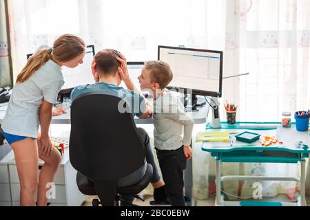 Père avec enfants essayant de travailler de la maison pendant la quarantaine. Restez à la maison, travaillez à partir du concept de maison pendant la pandémie de coronavirus Banque D'Images