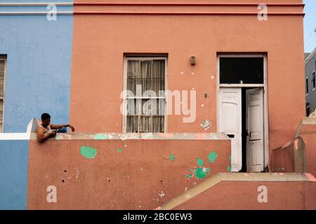 Afrique du Sud, le Cap, Schotsche Knoof, Bo Kaap, Wale St, l'homme s'est assis sur le feu de la maison non restaurée Banque D'Images