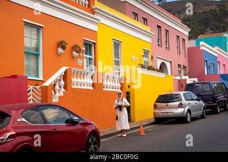 Afrique du Sud, le Cap, Schotsche Knoof, Bo Kaap, Wale St, femme garante une place de stationnement de voiture de maison rénovée colorée Banque D'Images