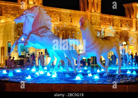 Nuit, photo de sculptures équestres dans la fontaine de Global Village, Dubaï, Emirats Arabes Unis. Banque D'Images