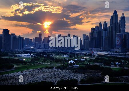 Coucher de soleil vue depuis l'appartement du 17ème étage à Dubaï, Emirats Arabes Unis, avec parcours de golf en premier plan. Banque D'Images