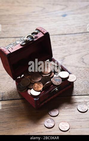 Pile de pièces US dans la petite poitrine en bois sur la table en bois vue du dessus Banque D'Images