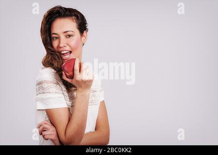 Femme mangeant une pomme rouge Banque D'Images