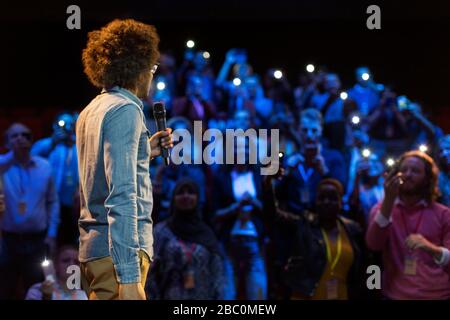 Public avec lampes de poche pour smartphone, écoute des haut-parleurs avec microphone Banque D'Images