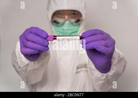 Les médecins des combinaisons et masques de protection détiennent un résultat positif de test sanguin pour le nouveau Coronavirus qui surpasse rapidement. Concept d'épandage de Coron Banque D'Images