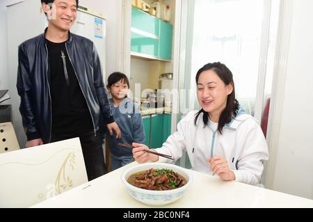 Cangzhou, la province chinoise de Hebei. 2 avril 2020. Le du Xiangxiang, une travailleuse médicale soutenant la province de Hubei, atteinte de virus, aime un plat préparé par son mari après son retour à la maison dans le comté de Yanshan à Cangzhou, dans la province de Hebei en Chine du nord, le 2 avril 2020. Les membres du cinquième lot d'équipes d'assistance médicale de la province de Heibei sont retournés chez eux après 14 jours de quarantaine. Crédit: Fu Xinchun/Xinhua/Alay Live News Banque D'Images