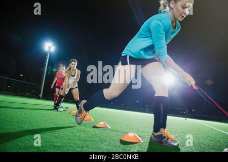 Les jeunes joueurs de hockey sur gazon qui pratiquent des exercices sportifs sur le terrain Banque D'Images