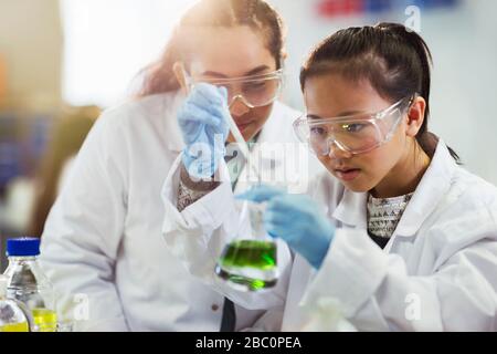 Des filles qui mènent des expériences de chimie en laboratoire de classe Banque D'Images