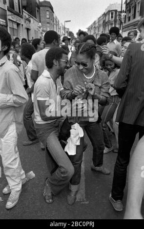 Notting Hill Carnival groupe de couple noir célébrant la fête, ayant amusant dansant la danse Bump dans la nuit. 1980 ROYAUME-UNI HOMER SYKES Banque D'Images