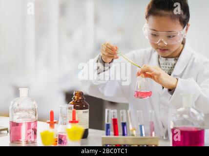 Une jeune étudiante qui effectue une expérience scientifique en salle de classe de laboratoire Banque D'Images