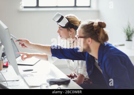 Les programmeurs informatiques programmant des lunettes de simulation de réalité virtuelle au bureau Banque D'Images