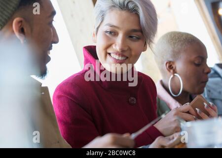 Jeune femme souriante parlant avec un ami Banque D'Images