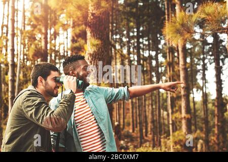 Jeunes hommes avec jumelles observation des oiseaux dans les bois Banque D'Images