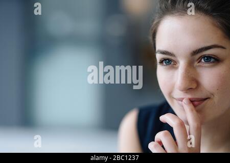 Portrait de la jeune femme souriante regardant à distance Banque D'Images