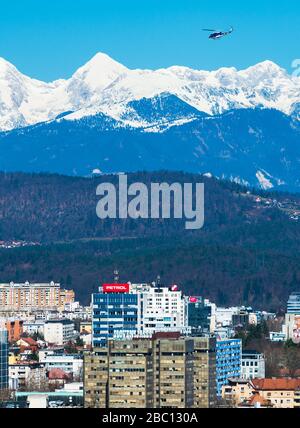 Ljubljana - mars 2017, la Slovénie : Ljubljana cityscape avec les montagnes enneigées en arrière-plan et la police hélicoptère volant dans le ciel Banque D'Images