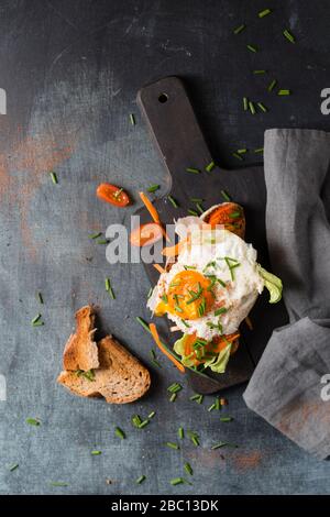 Œufs frits avec pain et légumes sur la planche à découper Banque D'Images