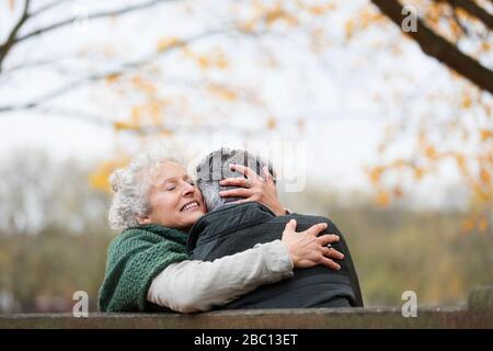 Affectueux, tendre couple senior embrassant dans le parc d'automne Banque D'Images
